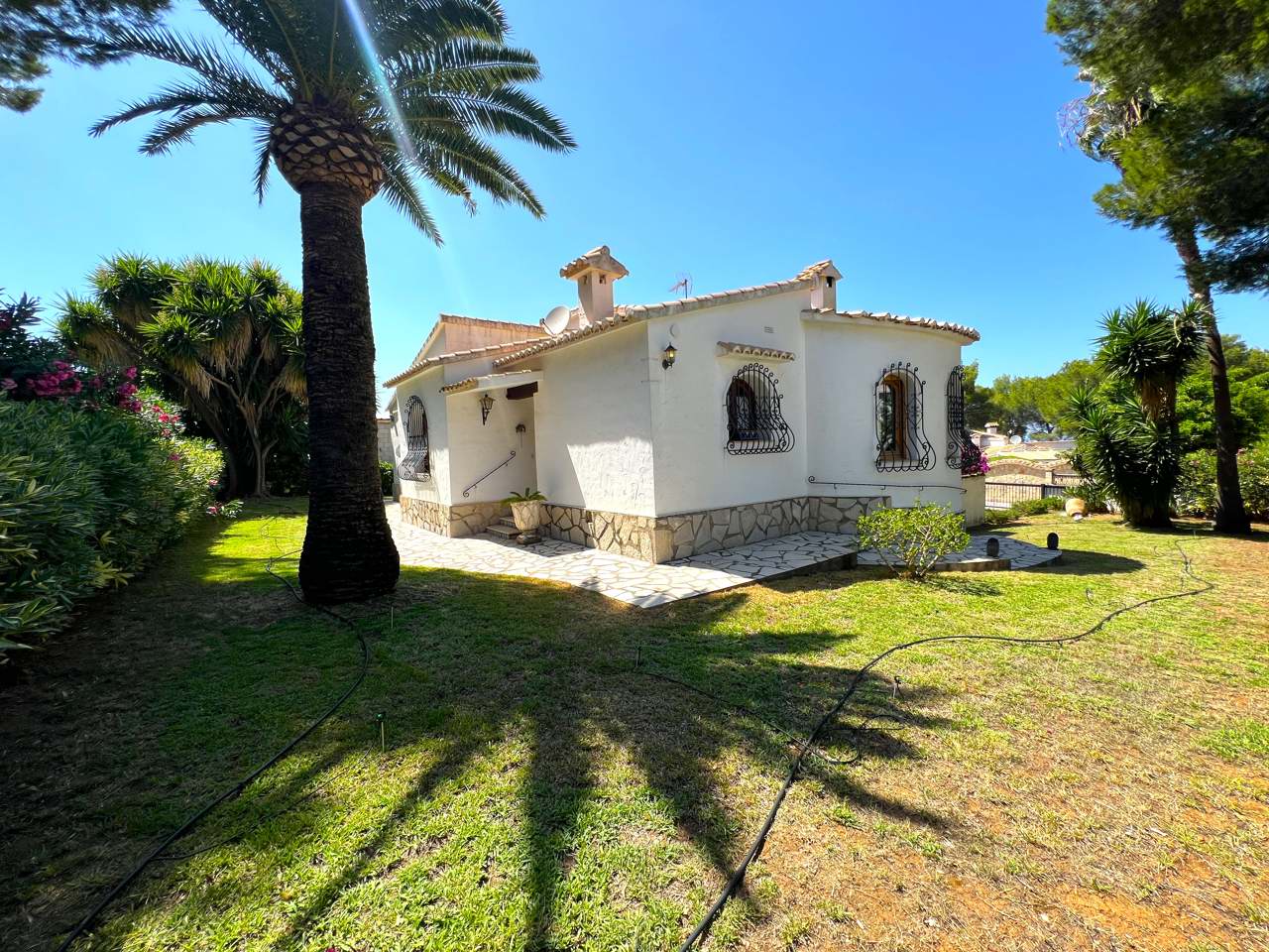 DEMO: fachada y jardín de otra villa en Dénia; no corresponde a Villa Isabel.